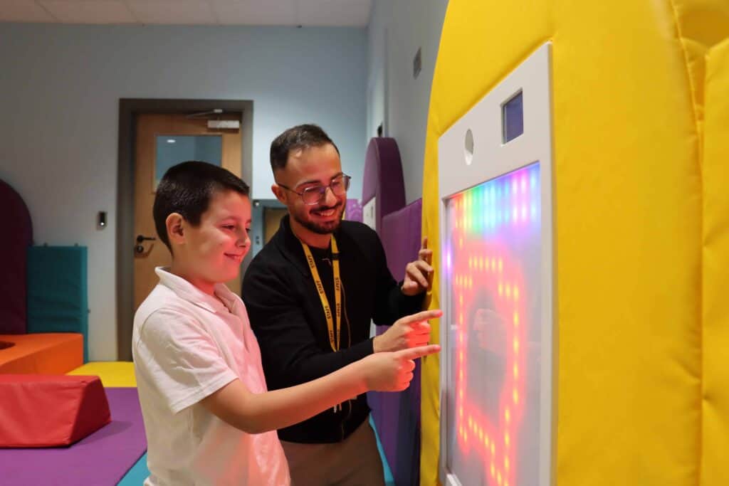 Children and adult interacting with an educational digital display at Cloud Design Box.